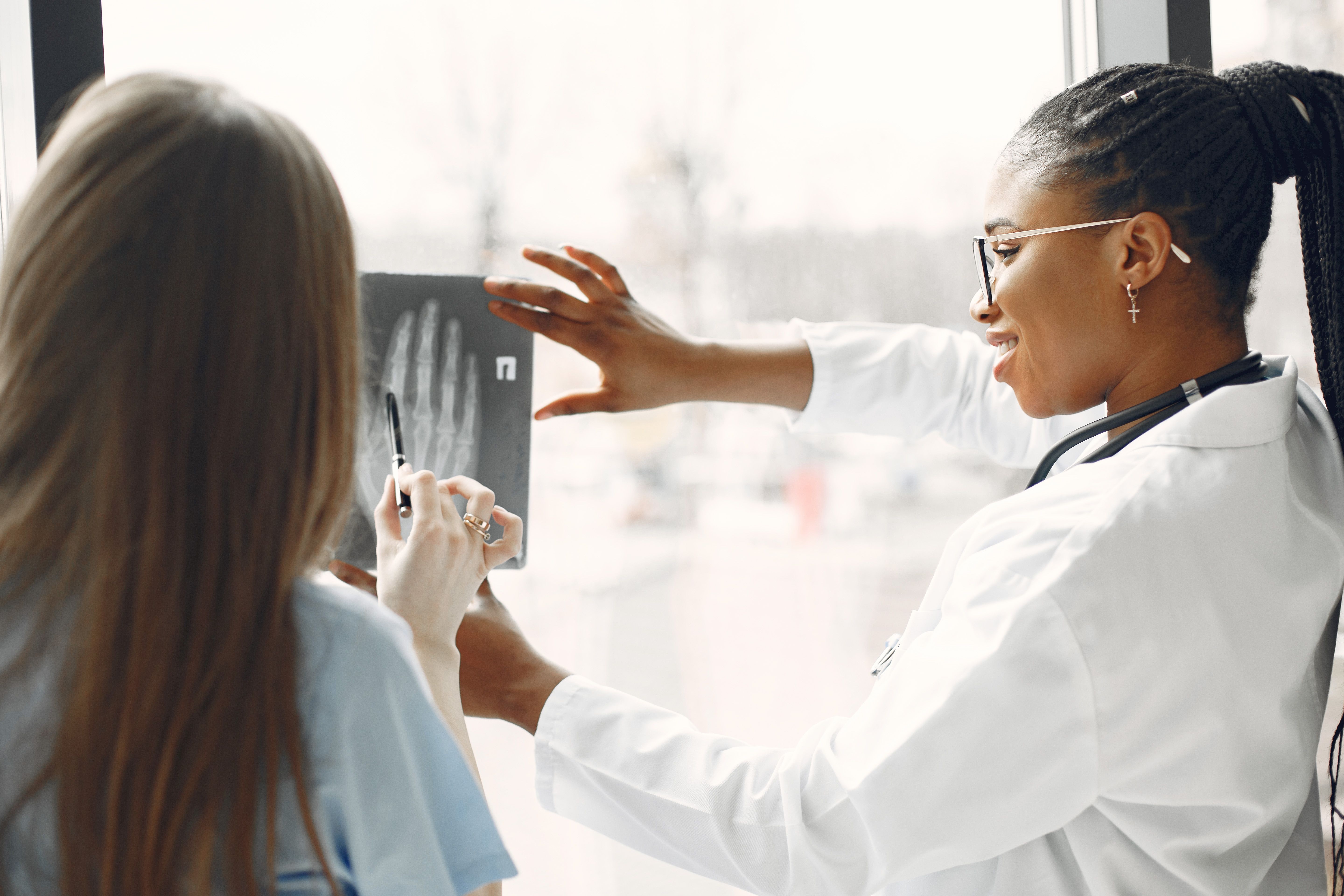 Radiologic technologist positioning imaging equipment for a patient
